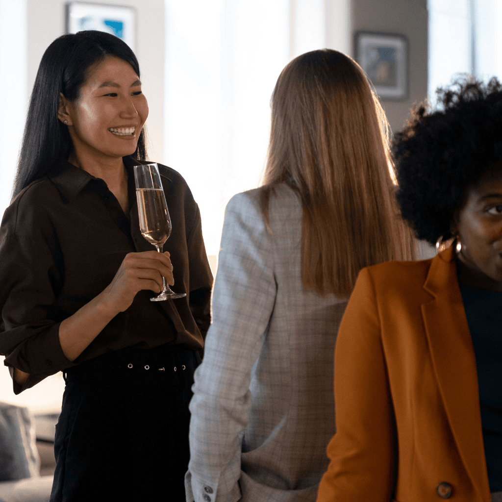 Confident woman standing at the head of a dinner table, leading a financial conversation